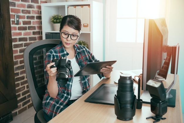 elegante diseñadora de fotografía de negocios femenina de belleza revisa la imagen del fotógrafo y usa el diseño de verificación de la computadora de la almohadilla móvil en la oficina de la empresa de estilo vintage.