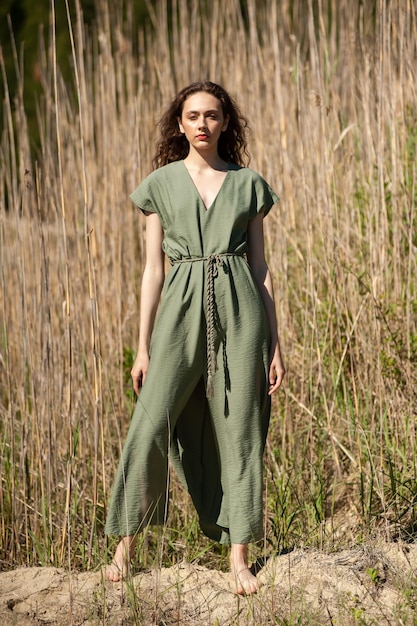 Elegante e atraente mulher sorridente magra na praia em estilo de verão roupa de tendência de moda despreocupada e feliz