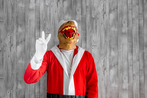 Foto elegante y elegante selfie de dinosaurio con cámara frontal que muestra el signo v aislado sobre fondo gris rojo noel.