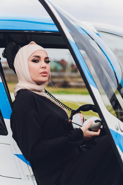 Elegante empresaria musulmana en un helicóptero
