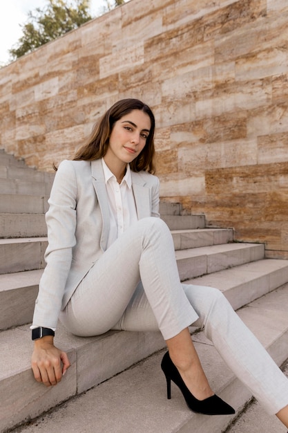 Foto elegante empresaria posando en las escaleras al aire libre