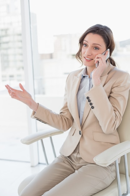 Elegante empresária usando telefone celular no escritório