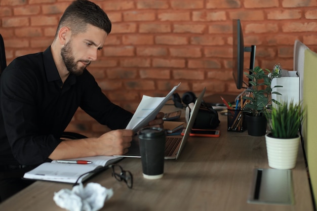 Elegante empresário moderno, analisando dados enquanto trabalhava no escritório.