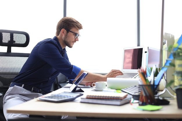 Elegante empresário moderno, analisando dados enquanto trabalhava no escritório.