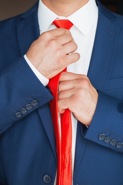 Elegante empresário um homem com um relógio endireita sua gravata