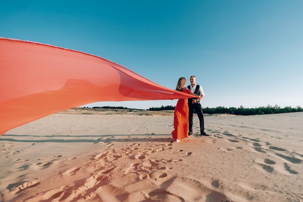 Elegante encantadora pareja posando en la playa