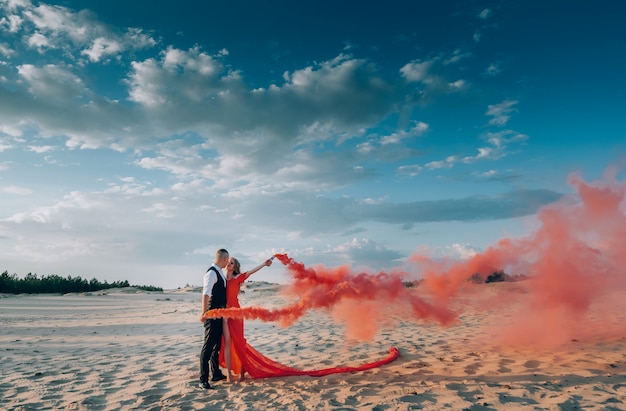 Elegante encantadora pareja posando en la playa