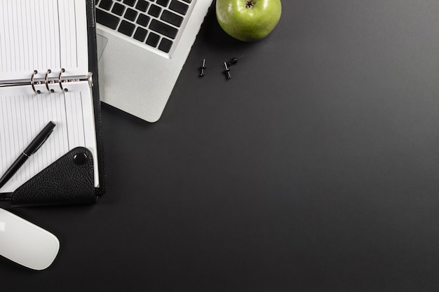 Elegante escritorio de oficina negro con laptop y taza de café