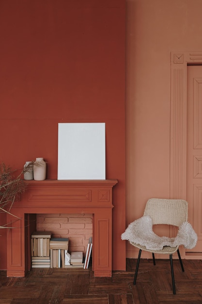 Elegante estilo escandinavo estilo hygge interior de la sala de estar Acogedora silla chimenea marco en blanco paredes rojas