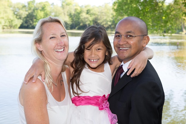 Elegante familia mixta con padre, madre y niña.