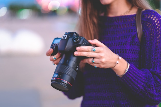 Elegante fotógrafo viajero ocasional mujer tomando fotos con cámara digital réflex digital y lente slr durante caminar por la ciudad europea