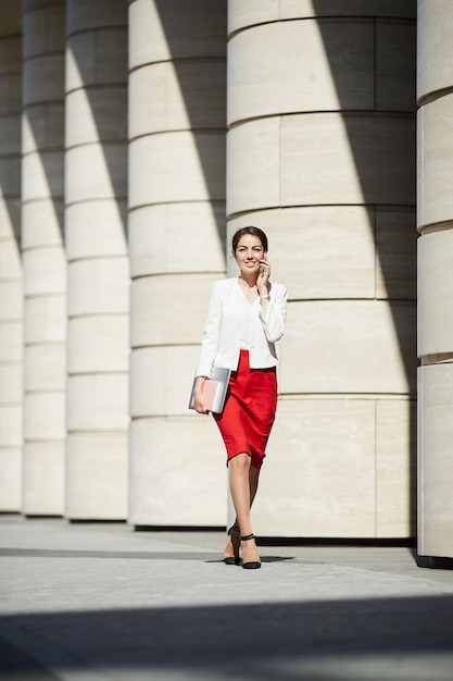 Elegante Frau, die im Sonnenlicht geht