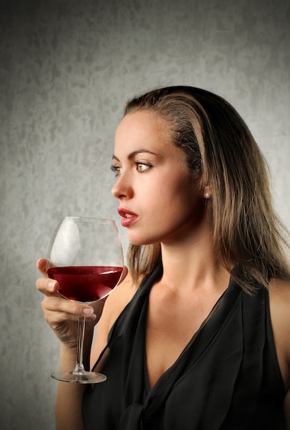 Elegante Frau, die Wein schmeckt