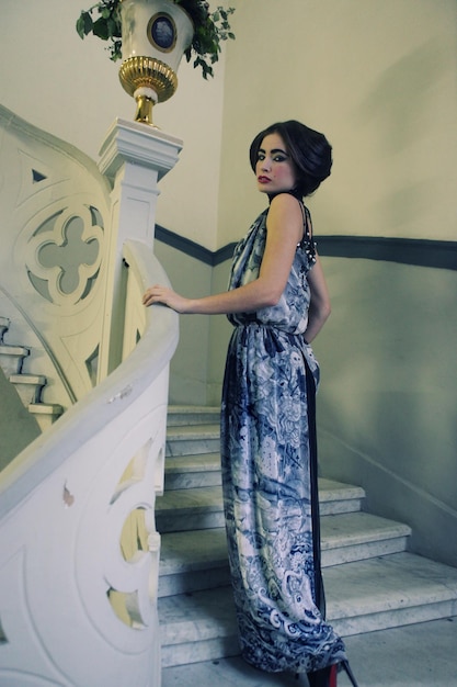 Elegante Frau im langen Kleid auf Weinlese-Treppe