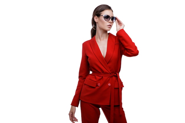 Elegante Frau im roten Anzug Jacke Hosen Sonnenbrille auf weißem Hintergrund Studio Shot Geschäftsfrau