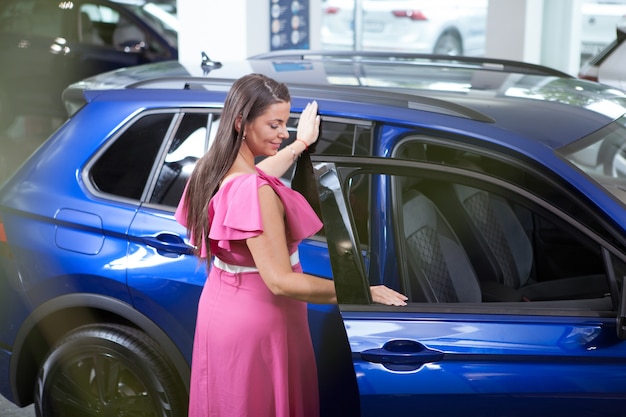 Elegante Frau in Übergröße, die ein SUV-Auto im Autohaus kauft