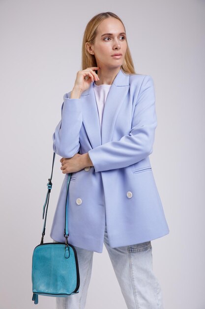 elegante Frau in hübschen blauen Jeans, Jacke auf weißem Hintergrund