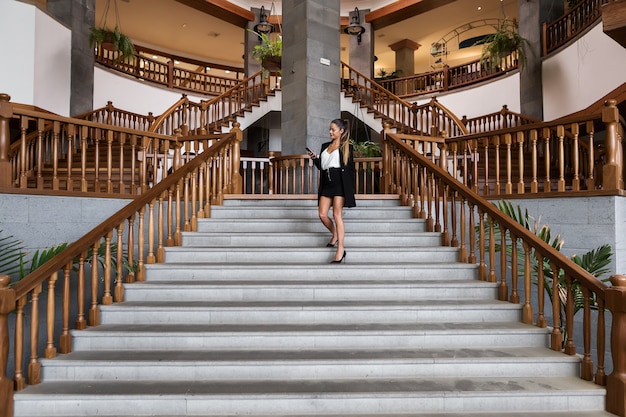 Elegante Frau mit Telefon auf der Treppe