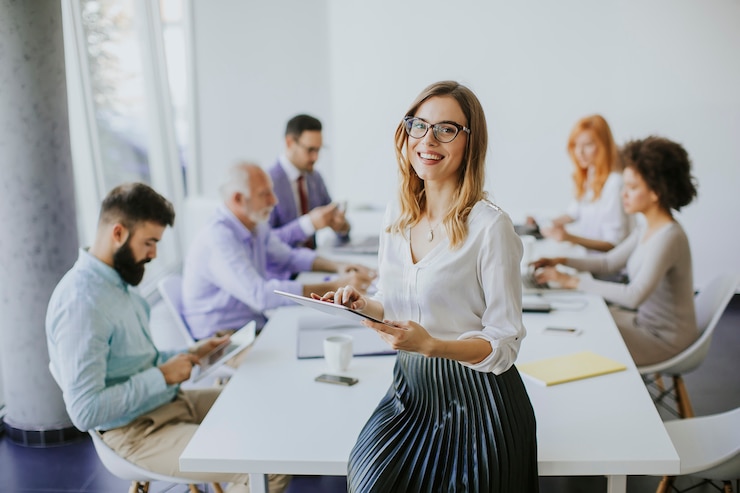 Foto elegante geschäftsfrau steht im büro mit einem digitalen tablet