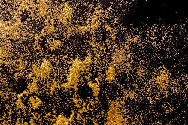 Foto elegante goldene glitzerfarbe auf schwarzem hintergrund