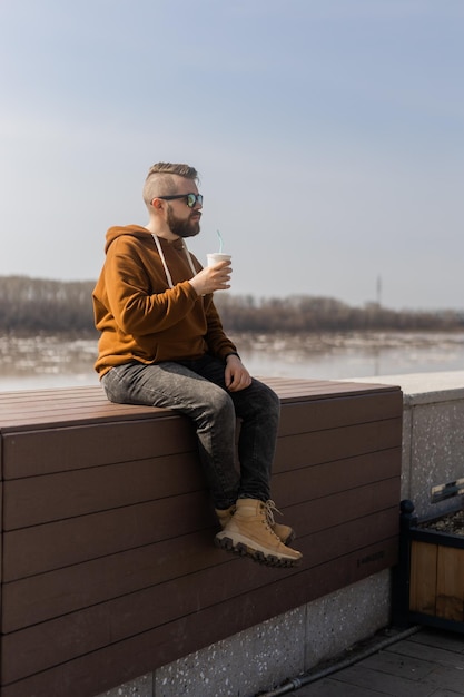 Elegante guapo hipster hombre sosteniendo bebidas cóctel primavera