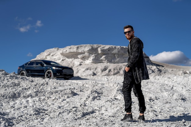 Elegante y guapo hombre de negocios de moda Joven modelo posando con coche