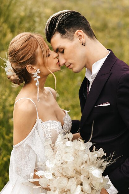 Foto elegante hermosa pareja de recién casados enamorados besándose juntos en la naturaleza