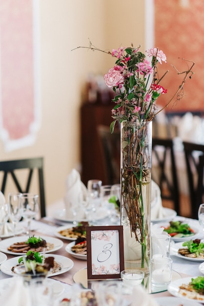 Elegante Hochzeitsdekoration aus natürlichen Blumen und grünen Elementen