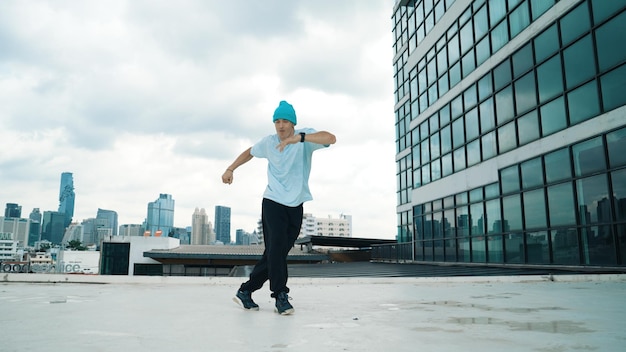 Elegante hombre caucásico bailando haciendo break dance en un rascacielos Imagen de un joven feliz practicando baile callejero Coreógrafo en una ciudad urbana Deporte al aire libre 2024 Esfuerzo