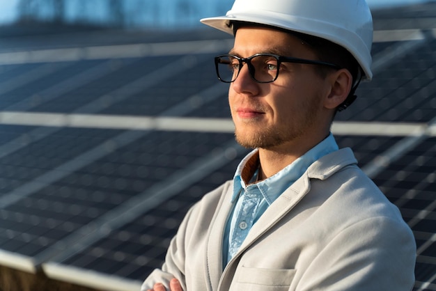 Elegante hombre de negocios con gafas frente al panel solar