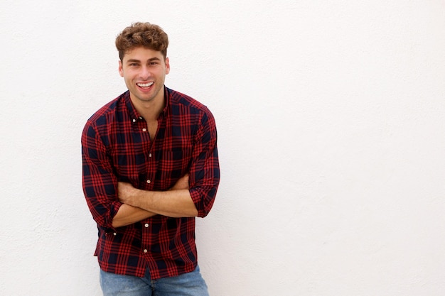 Elegante homem feliz em pé com os braços cruzados