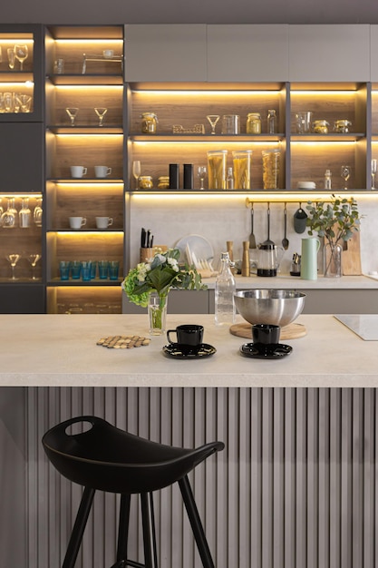 elegante interior de cocina de lujo en un espacioso apartamento ultramoderno en colores oscuros con iluminación LED súper fresca y una isla para cocinar