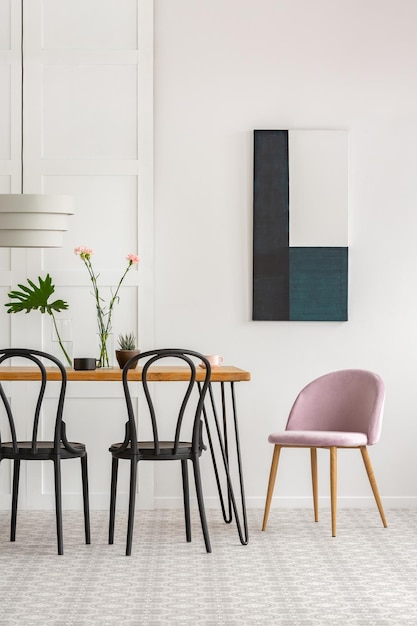 Foto elegante interior de comedor con sillas de madera negras y plantas verdes