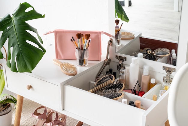 Elegante interior de habitación con elegante tocador y plantas de monstera