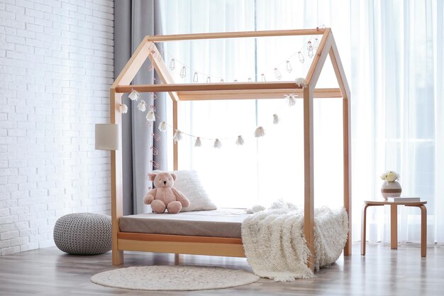 Elegante interior de habitación infantil con linda cama de madera