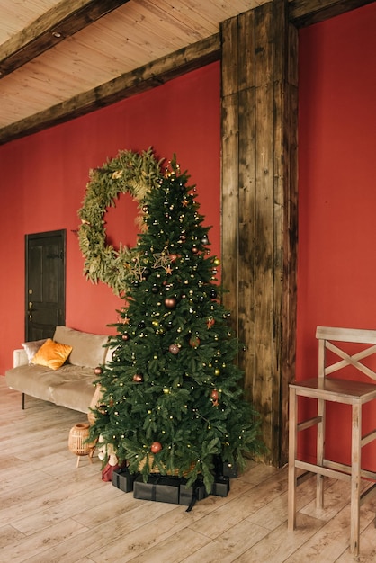 Elegante interior de la sala de estar con un árbol de Navidad sobre un fondo rojo.