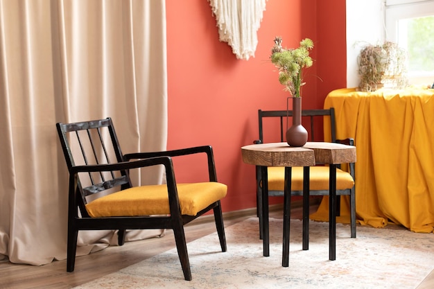 Elegante interior de salón con decoración casera. Mesa con sillón de diseño y madera cortada a sierra