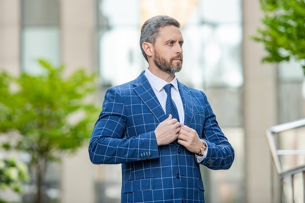 Elegante jefe de negocios con chaqueta en la foto de la calle del jefe de negocios con corbata