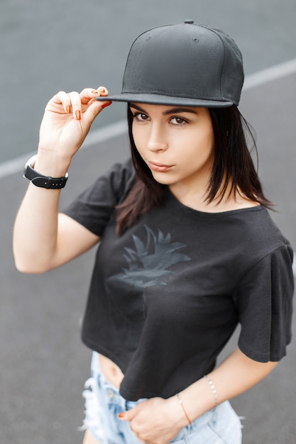 Elegante jovem bonita em um boné preto e camiseta.