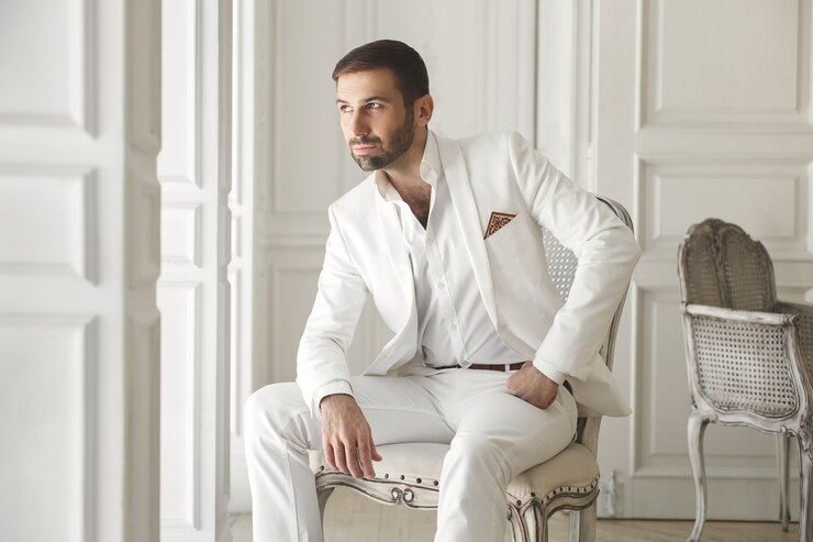 Foto elegante jovem bonito com uma barba em um terno branco clássico.
