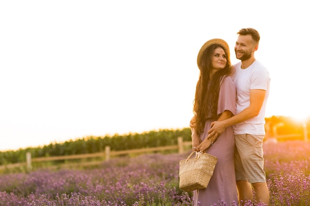 Elegante jovem casal adulto andando no campo de lavanda tendo um encontro romântico