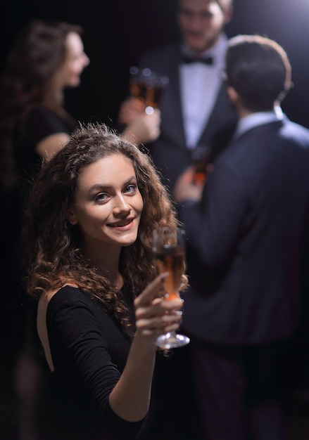 Elegante jovem levantando uma taça de champanhe nos feriados e eventos