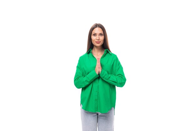 Elegante jovem morena magro com maquiagem em uma camisa verde sobre um fundo branco com espaço de cópia