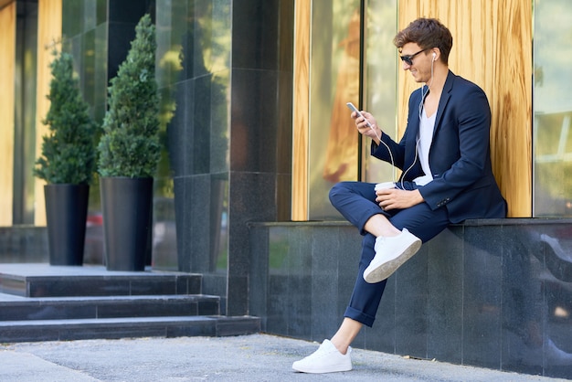 Elegante jovem usando Smartphone ao ar livre