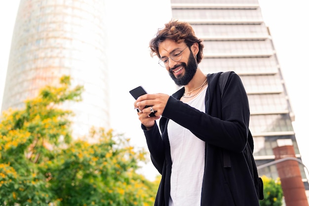 Elegante jovem usando um telefone celular na cidade