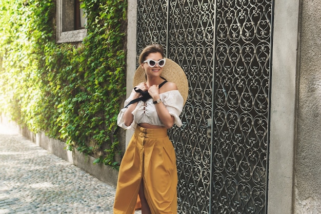 Elegante joven caminando por las calles de la pequeña ciudad italiana