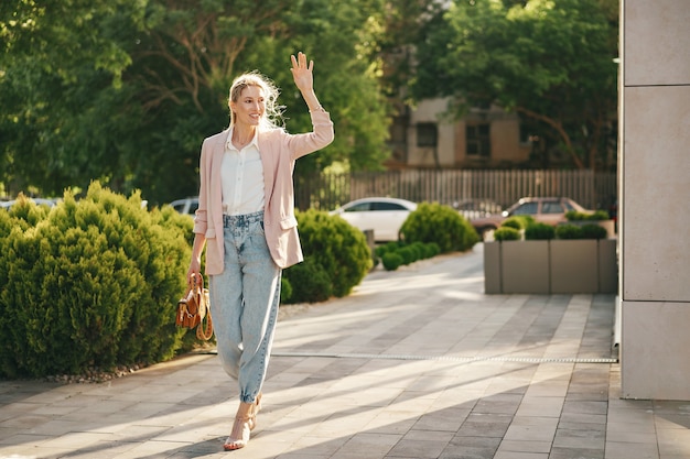 Elegante joven empresaria caminando por las calles de la ciudad en un día soleado