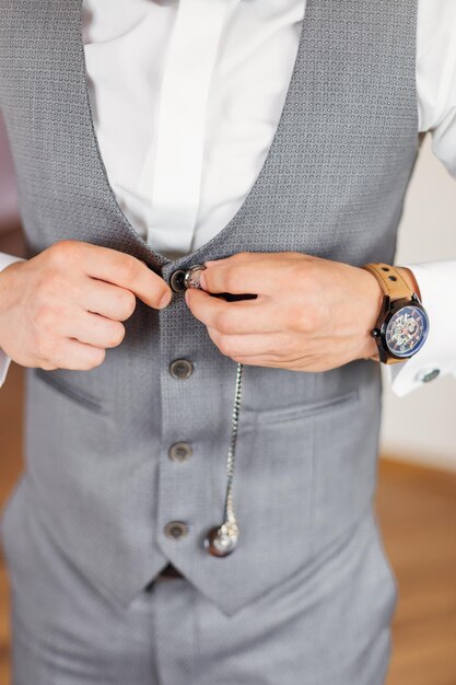 Elegante joven hombre de moda vistiéndose para una celebración de boda