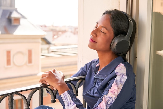 Elegante joven india disfrutando de la música en los auriculares