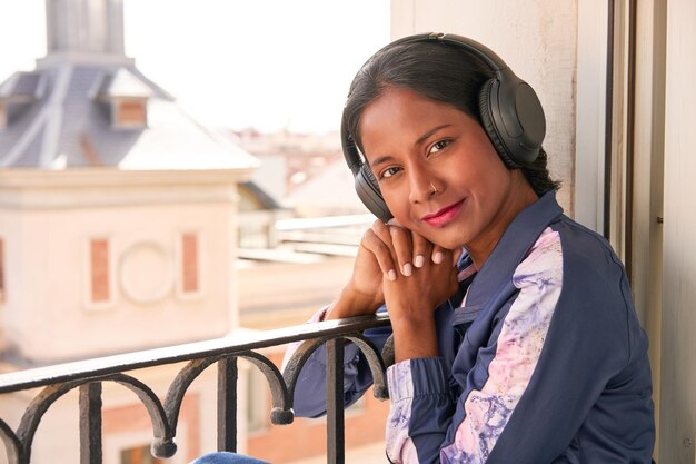 Elegante joven india disfrutando de la música en los auriculares